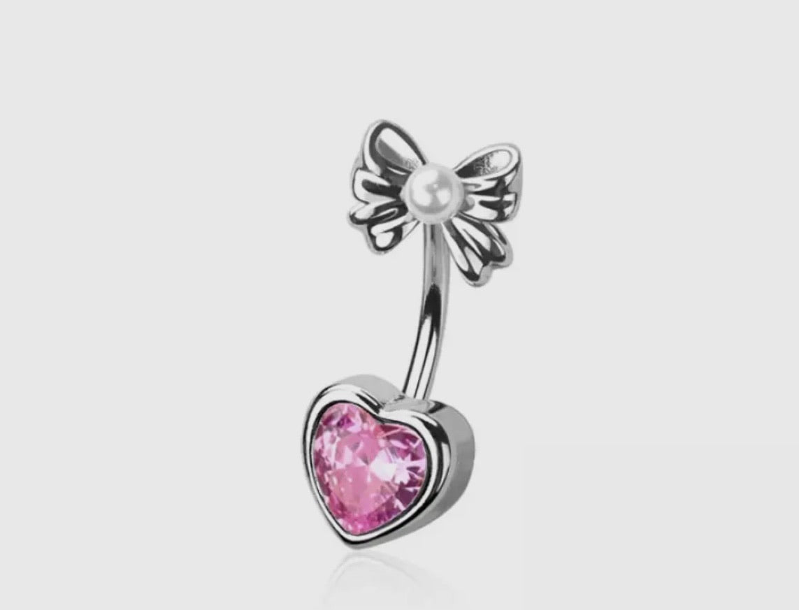 Cute with a little edge is just how we like it. Featuring a sparking genuine CZ heart shaped stone paired with a delicate bow detail for the perfect blend of flirty and feminine. It’s playful, sassy and made to stand out. Sweet details with after dark confidence. Available in silver or gold. Exclusive to our SSB Underground secret shop! 
Material: 316L SURGICAL STEEL/Alloy
Thickness: 14GA (1.6MM)
Length: 3/8" (10MM)
Made in the USA
Final Sale

