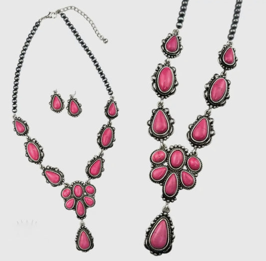 Turn heads and steal hearts y’all! This bold beauty features vibrant pink stones set in antique silver for the perfect mix of western charm and feminine flair. The statement floral inspired design brings serious cowgirl confidence. Wear it with your fave denim, graphic tee or flowy dress. And because we love a good extra this necklace comes with FREE matching earrings to complete the look. 
Made in the USA 
Length: 18”

 